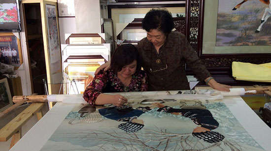 刘爱云大师对紫金湘绣徐向荣进行指导和研究绣刺方法。